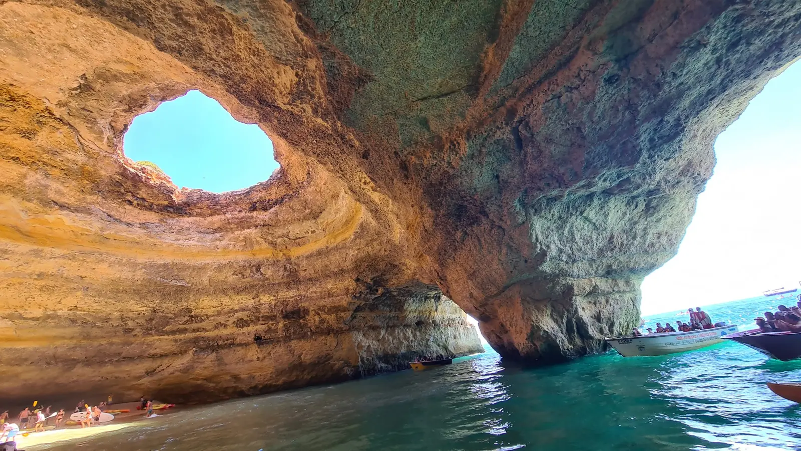 Interior da gruta de Benagil, com a abertura no teto e o areal