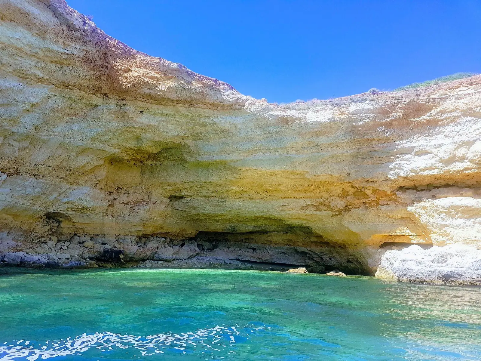 Arriba dourada sobre água turquesa, com céu azul