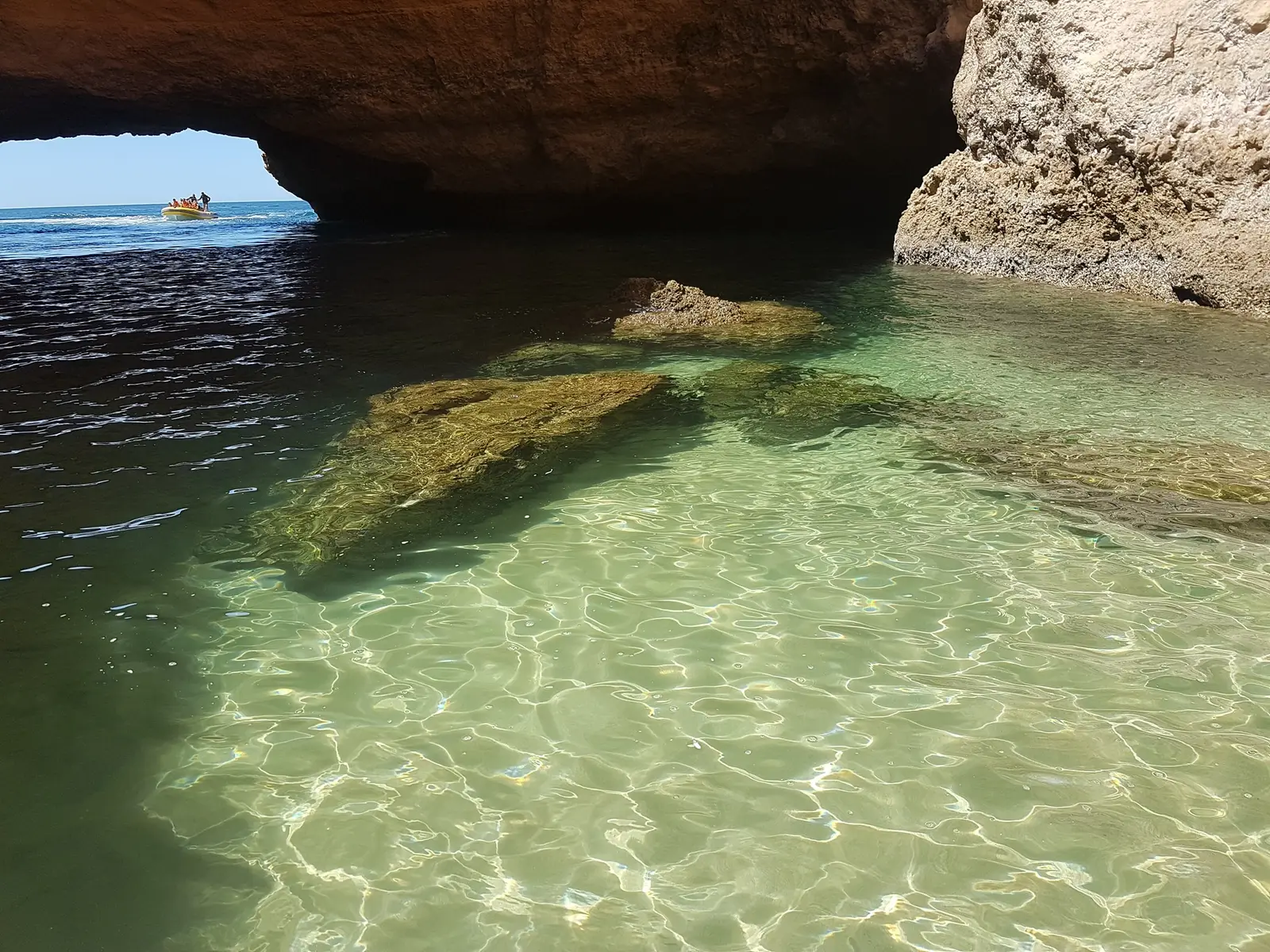 Água verde dentro de um arco, com um barco ao fundo