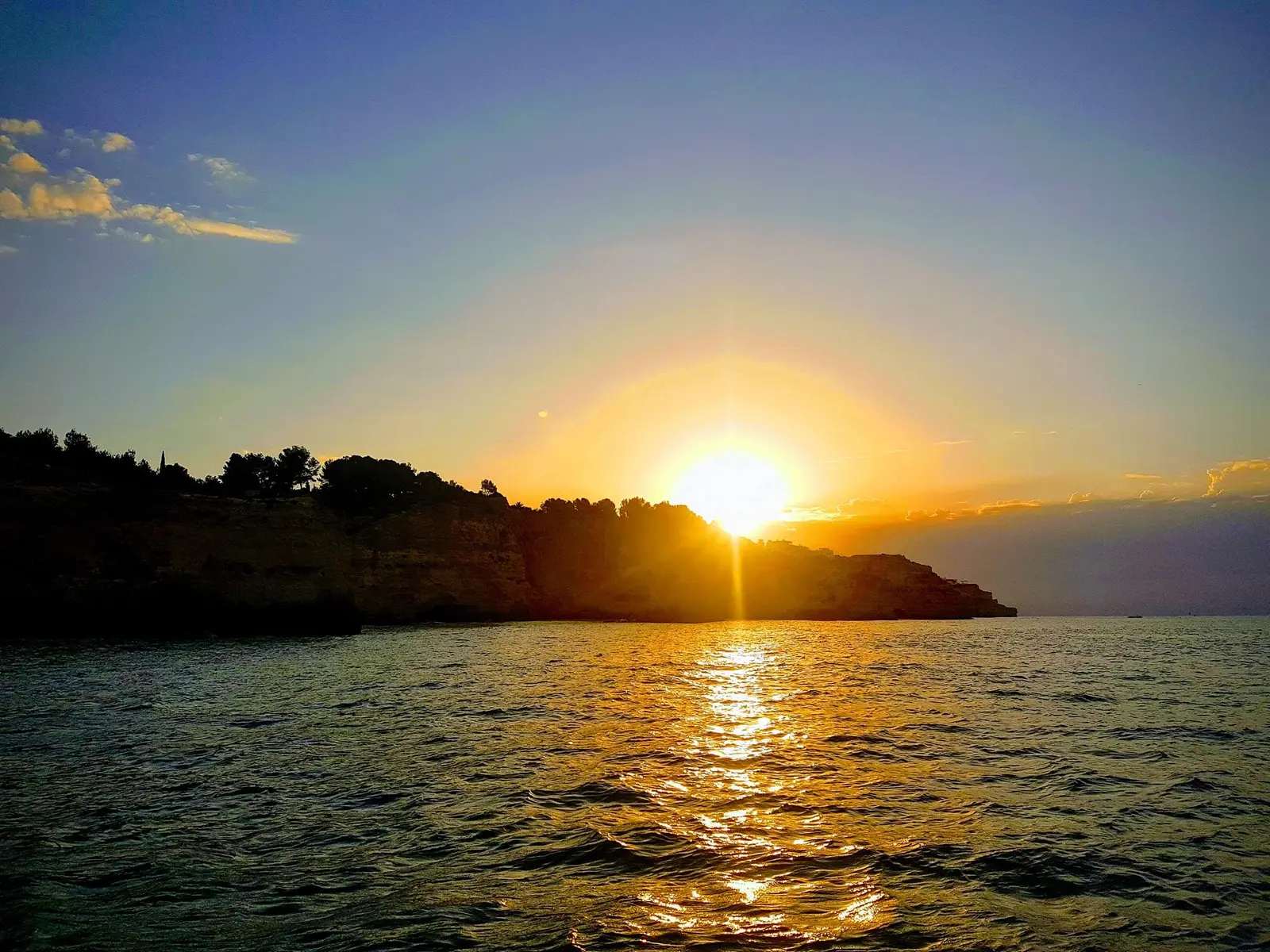 Pôr do sol atrás das arribas, com um rasto de luz no mar